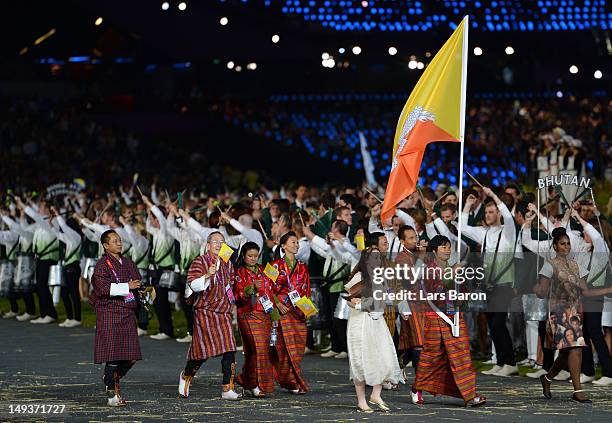 Sherab Zam of the Bhutan Olympic archery team carries her country's flag during the Opening Ceremony of the London 2012 Olympic Games at the Olympic...