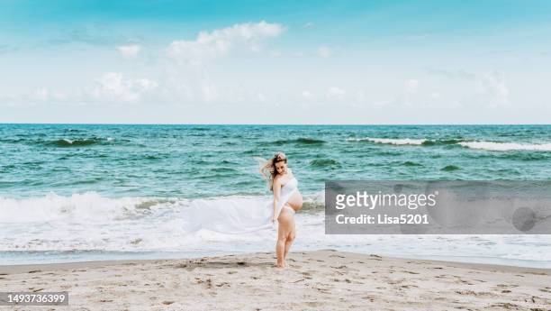 beautiful pregnant woman with exposed belly in flowing dress in an idyllic beach location, hope anticipation and new life - beautiful perfection exposed lady bildbanksfoton och bilder