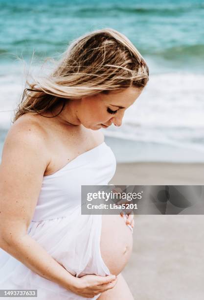 beautiful pregnant woman with exposed belly in flowing dress in an idyllic beach location, hope anticipation and new life - beautiful perfection exposed lady stock pictures, royalty-free photos & images