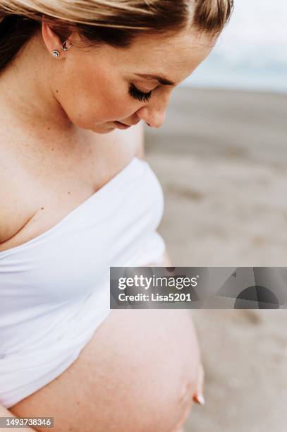 beautiful pregnant woman with exposed belly in flowing dress in an idyllic beach location, hope anticipation and new life - beautiful perfection exposed lady bildbanksfoton och bilder