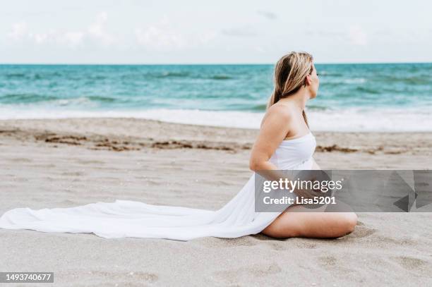 beautiful pregnant woman with exposed belly in flowing dress in an idyllic beach location, hope anticipation and new life - beautiful perfection exposed lady stock pictures, royalty-free photos & images