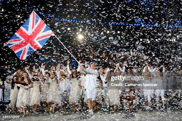 Sir Chris Hoy of the Great Britain Olympic cycling team carries his country's flag as he leads Great Britain into the stadium during the Opening...