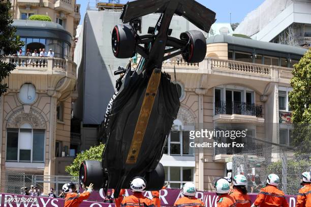 The car of Lewis Hamilton of Great Britain and Mercedes is lifted on a crane after he crashed during final practice ahead of the F1 Grand Prix of...