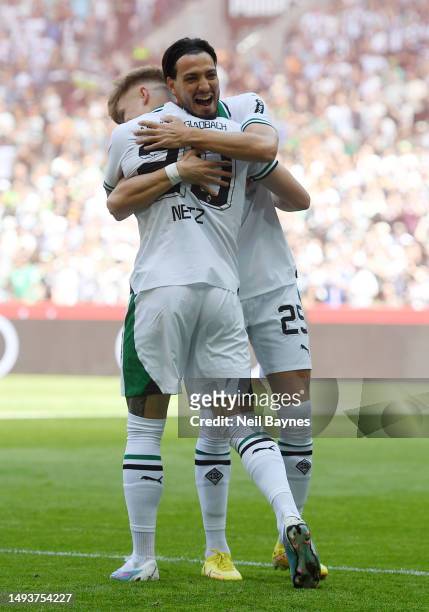 Luca Netz of Borussia Moenchengladbach celebrates with teammate Ramy Bensebaini after scoring the team's first goal during the Bundesliga match...