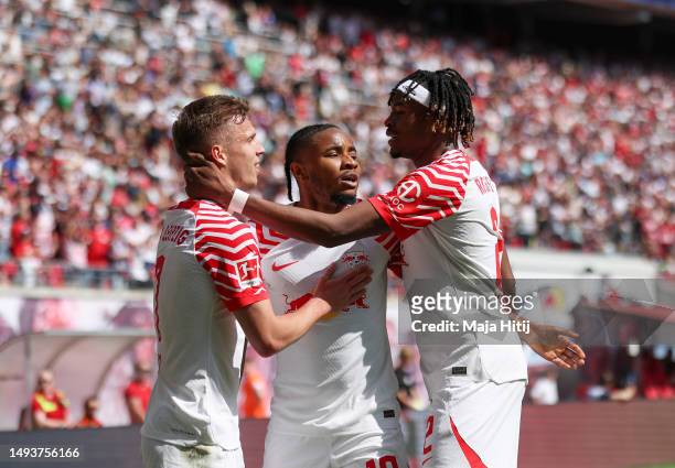 Christopher Nkunku of RB Leipzig celebrates with teammates Mohamed Simakan and Dani Olmo after scoring the team's second goal during the Bundesliga...