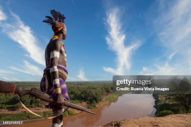 ethiopia. karo tribe man patrolling the omo river - afrikanischer volksstamm stock-fotos und bilder