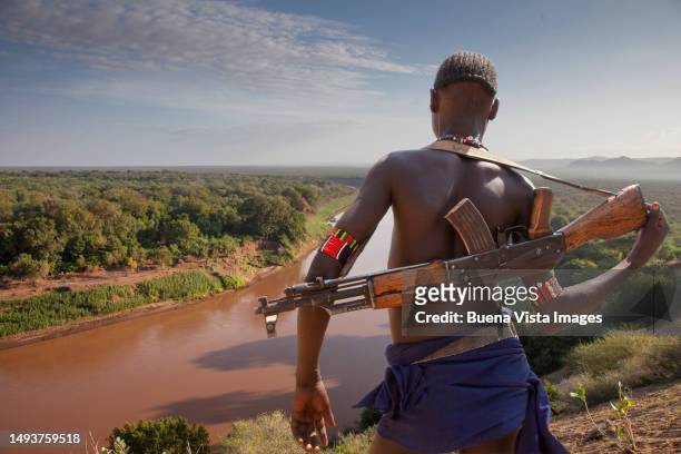 ethiopia. karo tribe man patrolling the omo river - cultura tribal africana - fotografias e filmes do acervo