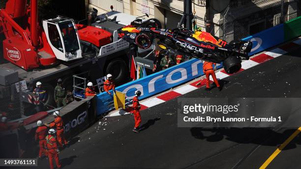 The car of Sergio Perez of Mexico and Oracle Red Bull Racing is removed from the circuit by a crane after he crashed during qualifying ahead of the...