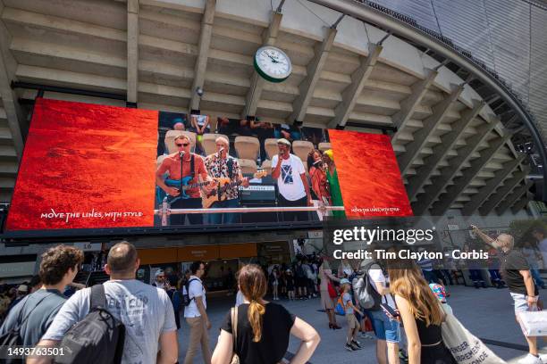Spectators watch Yannick Noah and his band on the big screen as he plays on Court Philippe Chatrier during Yannick Noah day at the 2023 French Open...