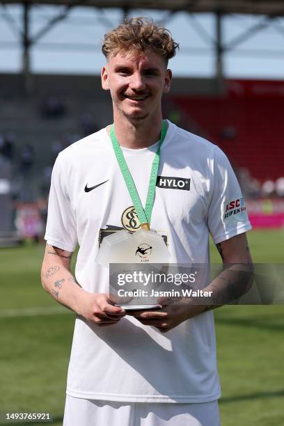 Nick Woltemade of Elversberg poses for a picture presenting the 'Player of the 3.Liga season' trophy after the 3. Liga match between FC Ingolstadt 04...