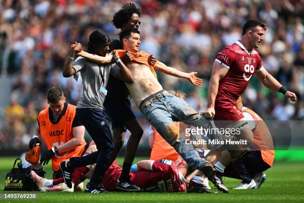 Just Stop Oil' protestor invades the pitch and is apprehended by stewards and Tom Curry of Sale Sharks during the Gallagher Premiership Final between...