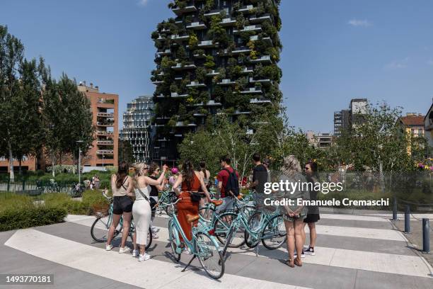 Tourist stand next to their bicycles as they visit the Porta Nuova district and the "Bosco Verticale" building on May 27, 2023 in Milan, Italy.