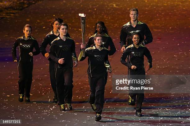 Young athlete who is joined by six others representing Britain's hopes for the next Olympics carries the Olympic torch during the Opening Ceremony of...