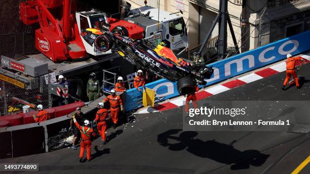 The car of Sergio Perez of Mexico and Oracle Red Bull Racing is removed from the circuit by a crane after he crashed during qualifying ahead of the...