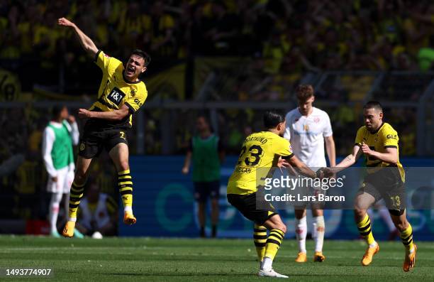 Raphael Guerreiro celebrates with Emre Can of Borussia Dortmund after scoring the team's first goal during the Bundesliga match between Borussia...