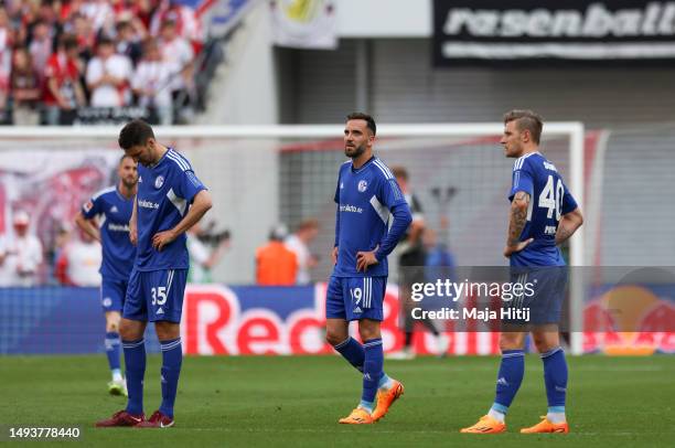 Sepp van den Berg, Sebastian Polter and Moritz Jenz of FC Schalke 04 react after the fourth goal of RB Leipzig scored by Christopher Nkunku during...