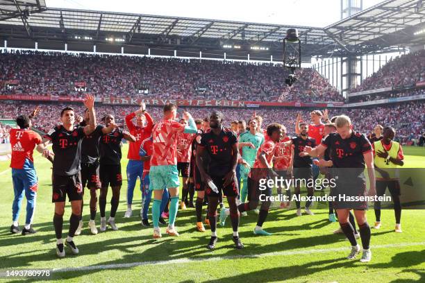 Joao Cancelo, Dayot Upamecano and Matthijs de Ligt of FC Bayern Munich celebrate winning the Bundesliga title following victory in the Bundesliga...