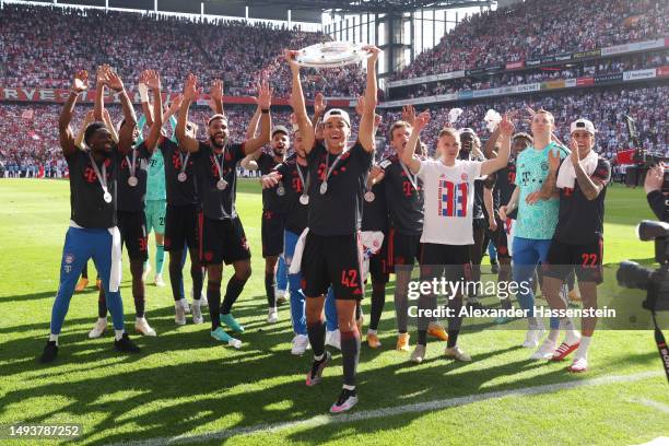 Jamal Musiala of FC Bayern Munich celebrates with the Bundesliga Meisterschale trophy after the team's victory in the Bundesliga match between 1. FC...
