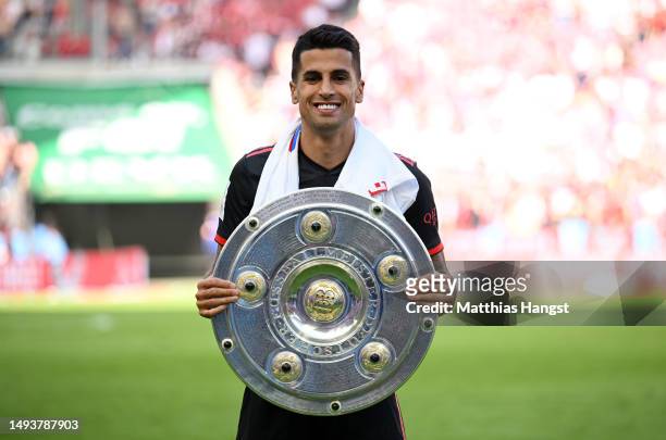 Joao Cancelo of FC Bayern Munich poses for a photo with the Bundesliga Meisterschale trophy after the team's victory in the Bundesliga match between...