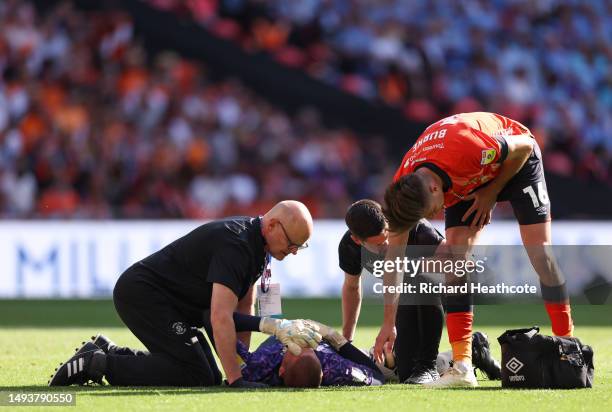 Ethan Horvath of Luton Town receives medical treatment on the pitch after clashing with Reece Burke of Luton Town during the Sky Bet Championship...