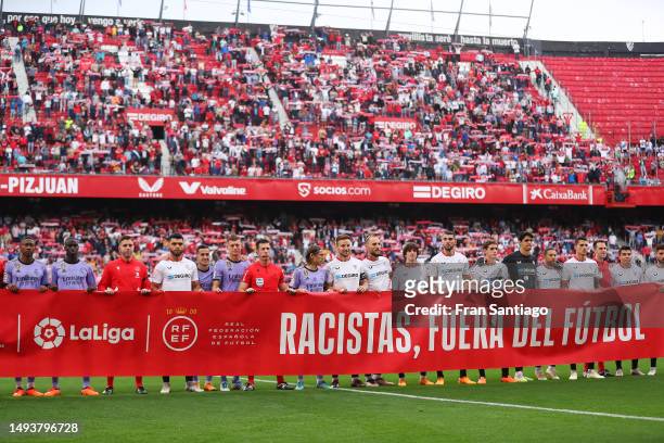 Players from both teams and match officials pose for a photo with a banner against racism prior to the LaLiga Santander match between Sevilla FC and...