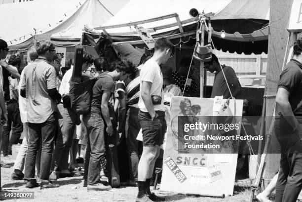 Festival goers patronize the Student Nonviolent Coordinating Committee booth at the Newport Folk Festival in July 1966 in Newport, Rhode Island.
