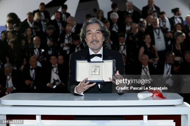 Kōji Yakusho poses with the Best Actor Award for 'Perfect Days' during the Palme D'Or winners photocall at the 76th annual Cannes film festival at...