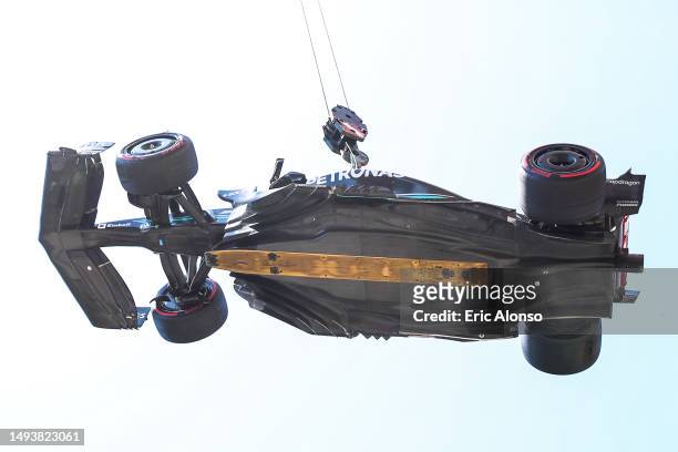 The car of Lewis Hamilton of Great Britain and Mercedes is lifted on a crane after he crashed during final practice ahead of the F1 Grand Prix of...