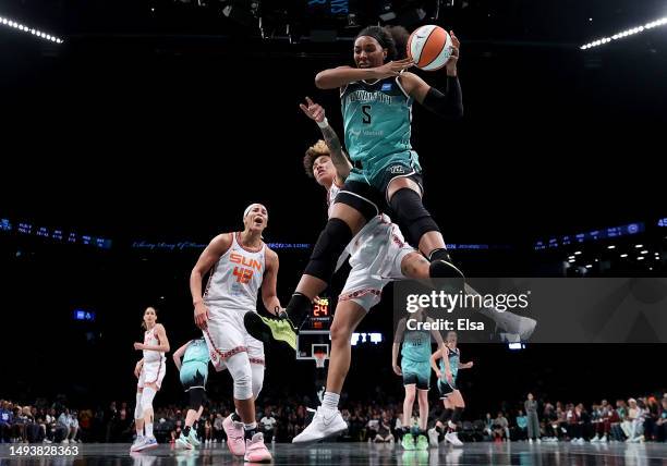 Kayla Thornton of the New York Liberty grabs the rebound before Natisha Hiedeman of the Connecticut Sun as Brionna Jones of the Sun reacts in the...