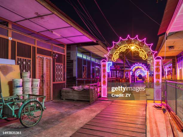neon lights at lee jetty at dusk - clan jetties floating village of penang, malaysia - penang state stock pictures, royalty-free photos & images