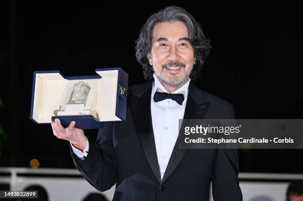 Kōji Yakusho poses with the Best Actor Award for 'Perfect Days' during the Palme D'Or winners photocall at the 76th annual Cannes film festival at...