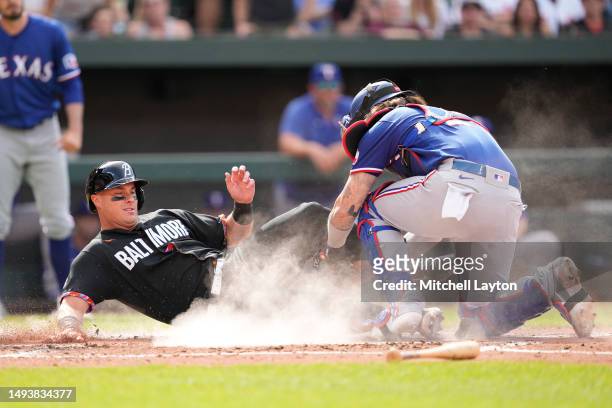 Jonah Heim of the Texas Rangers tags out James McCann of the Baltimore Orioles trying to score on a Adam Frazier single in the second inning during a...