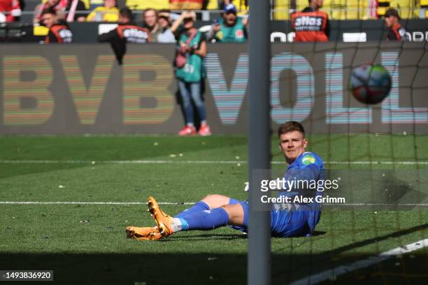 Raphael Guerreiro of Borussia Dortmund scores the team's first goal against Finn Dahmen of Mainz during the Bundesliga match between Borussia...