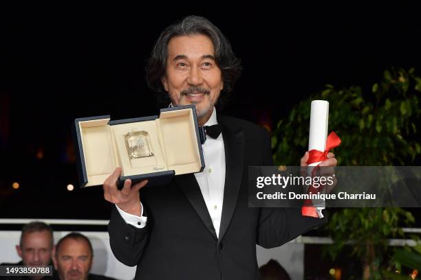 Kōji Yakusho poses with the Best Actor Award for 'Perfect Days' during the Palme D'Or winners photocallat the 76th annual Cannes film festival at...