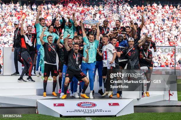 Thomas Mueller, Manuel Neuer and Joshua Kimmich of FC Bayern Munich lift the Bundesliga Meisterschale trophy after the Bundesliga match between 1. FC...