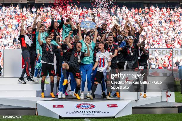 Thomas Mueller, Manuel Neuer and Joshua Kimmich of FC Bayern Munich lift the Bundesliga Meisterschale trophy after the Bundesliga match between 1. FC...