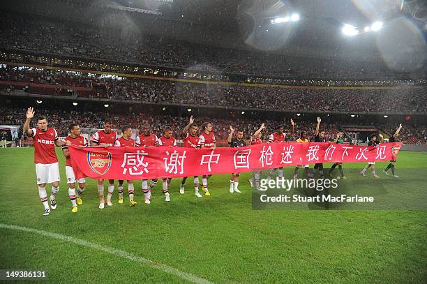 The Arsenal team hold a banners saying thank you to the Chinese fans for their support after the pre-season Asian Tour friendly match between Arsenal...