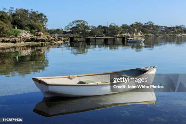 wooden dinghy and rustic jetty. calm sea at coffin bay an oyster farming town on the southern tip of the eyre peninsula. south australia. - rowboat stock pictures, royalty-free photos & images