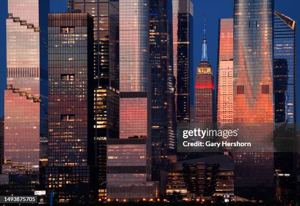 The Empire State Building standing between the towers of Hudson Yards marks Memorial Day weekend by lighting in red, white and blue in New York City...