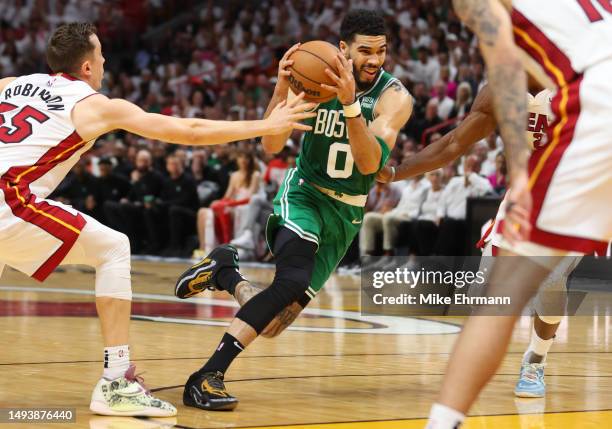 Jayson Tatum of the Boston Celtics drives to the net ahead of Jimmy Butler of the Miami Heat during the second quarter in game six of the Eastern...