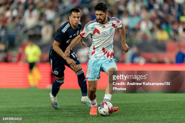 Mauricio Pineda of Chicago Fire FC passes the ball as Bobby Wood of New England Revolution closes during a game between Chicago Fire FC and New...