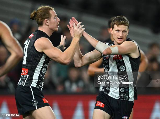 Will Hoskin-Elliott of the Magpies is congratulated by team mates after kicking a goal during the round 11 AFL match between Collingwood Magpies and...