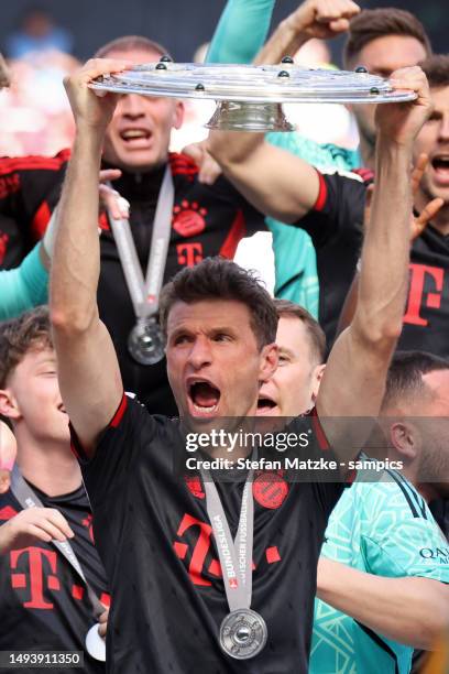 Thomas Mueller of Bayern Muenchen lifts the Bundesliga Meisterschale trophy after the team's victory in the Bundesliga match between 1. FC Köln and...