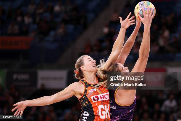 Lauren Moore of the Giants and Donnell Wallam of the Firebirds compete for the ball during the round 11 Super Netball match between Giants Netball...