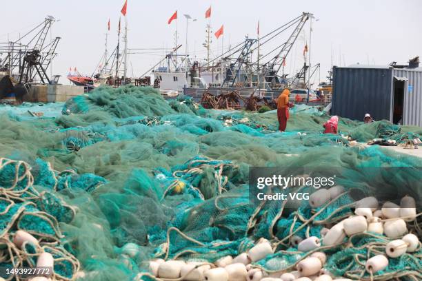 Fishermen mend their fishing nets in preparation for shrimp harvest season on May 28, 2023 in Lianyungang, Jiangsu Province of China.