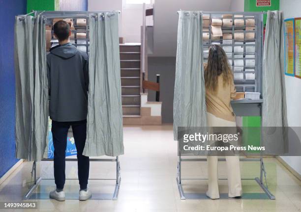 Two people exercise their right to vote in a booth at a polling station on May 28 in Madrid, Spain. Today, 28M, municipal elections are being held in...
