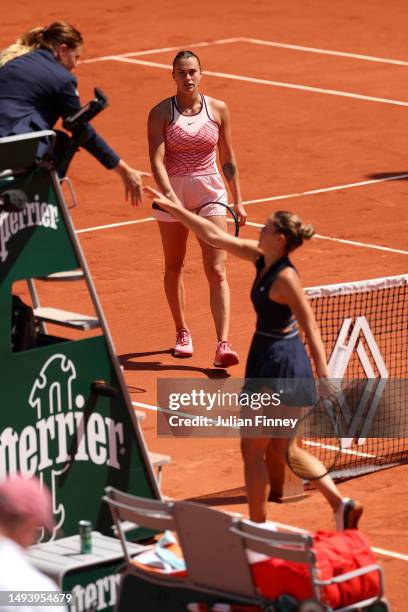 Marta Kostyuk of Ukraine shakes hands with the umpire before avoiding shaking hands with Aryna Sabalenka as she looks on after their Women's Singles...