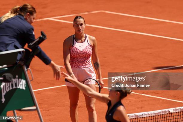 Marta Kostyuk of Ukraine shakes hands with the umpire before avoiding shaking hands with Aryna Sabalenka as she looks on after their Women's Singles...