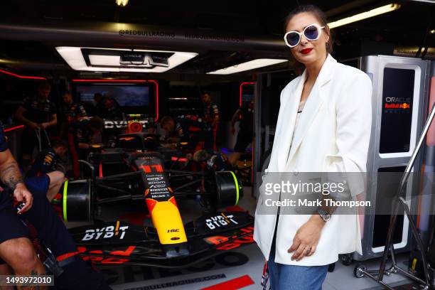 Maria Sharapova poses for a photo next to the car of Sergio Perez of Mexico and Oracle Red Bull Racing in the garage during the F1 Grand Prix of...