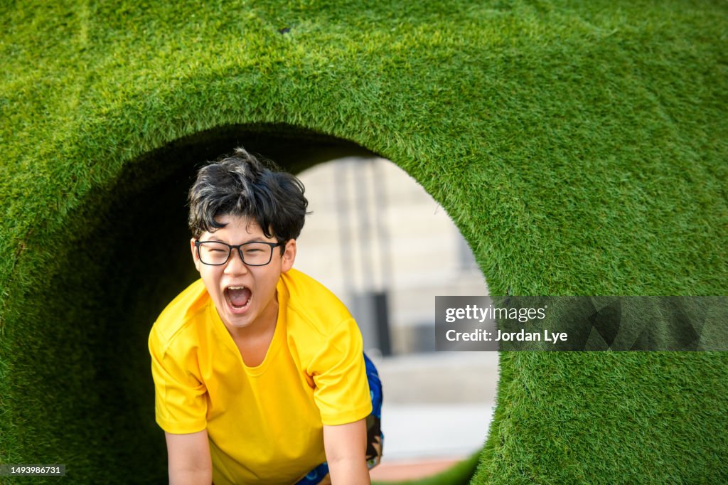 Chinese boy feeling exciment in playground